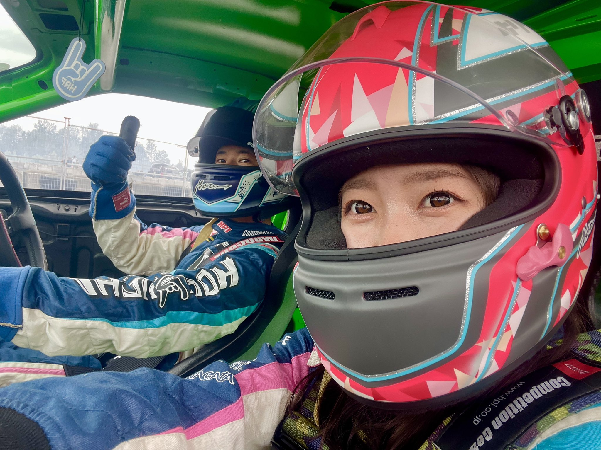 レーシングスーツ姿でピースサイン